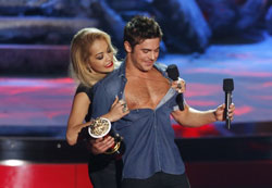 One of the many not-at-all-scripted moments at the 2014 MTV Movie Awards Rita Ora rips the shirt of Best Shirtless Performance Winner Zac Efron